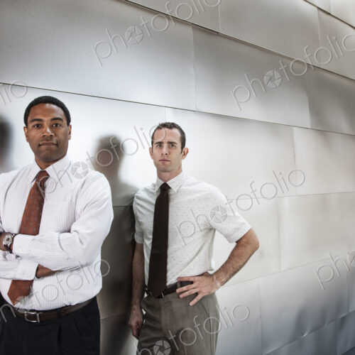 Two businessmen standing in an office corridor. Two businessmen standing in an office corridor.