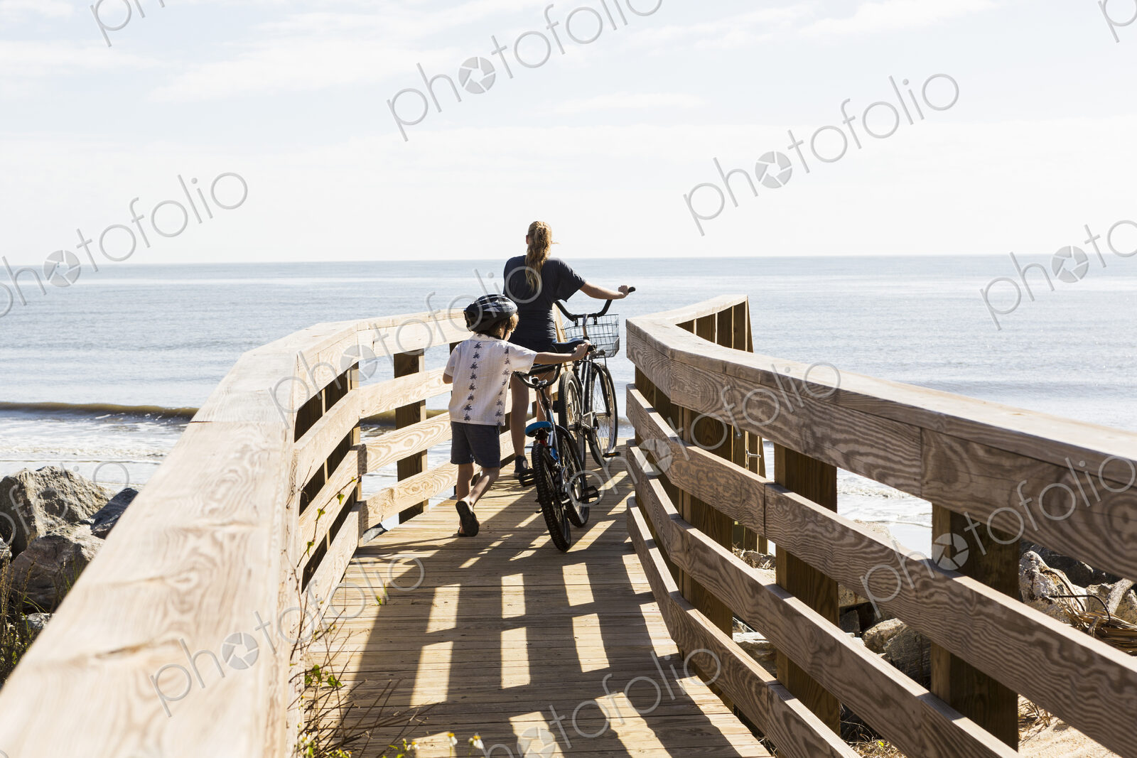 Two children, brother and sister on wooden bridge with bikes