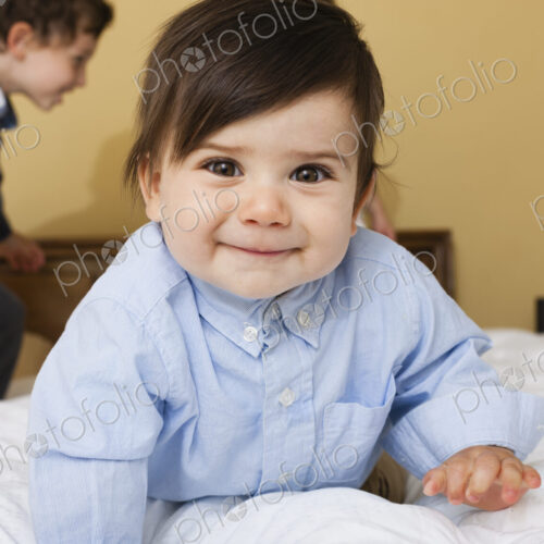 Two children playing on a bed. Two children playing on a bed.