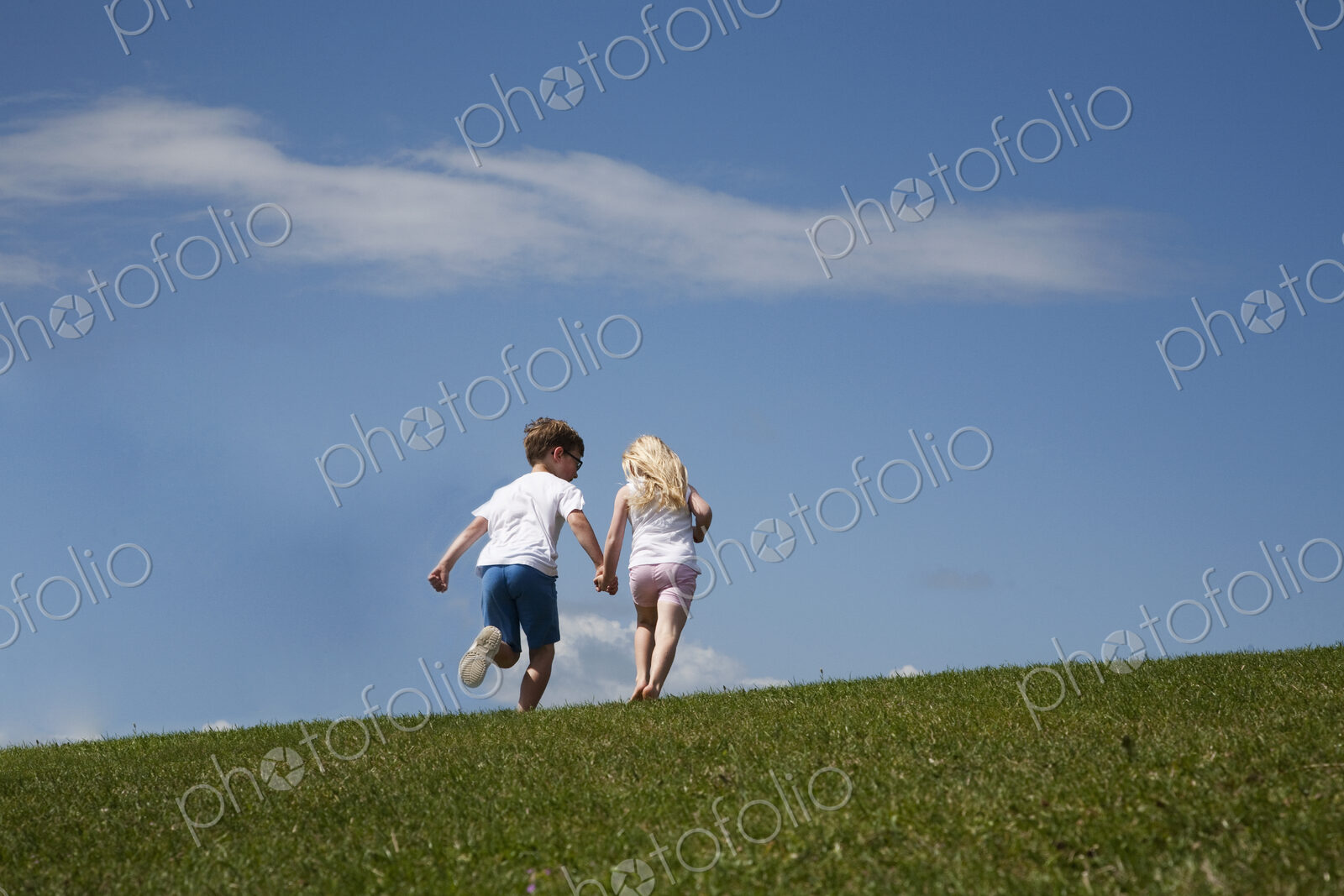 Two children running up a hill