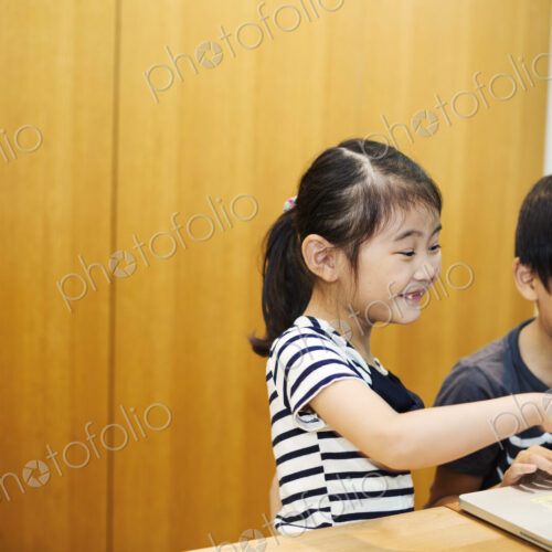 Two children sharing a laptop computer.