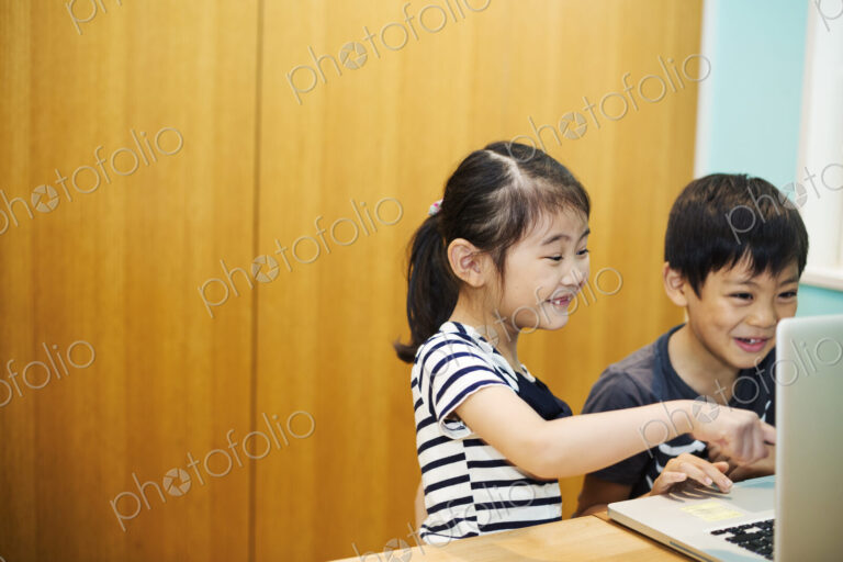 Two children sharing a laptop computer.
