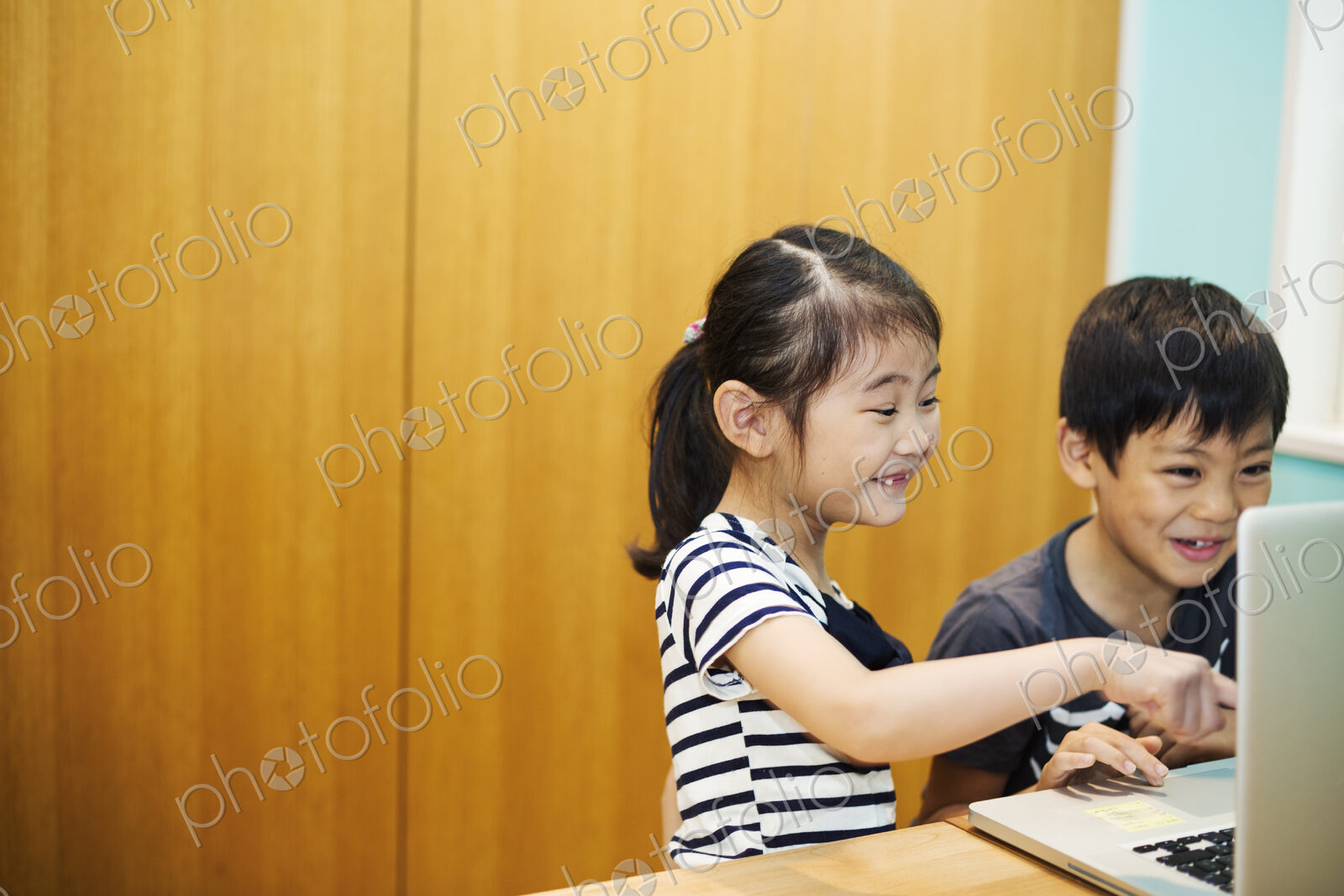 Two children sharing a laptop computer.