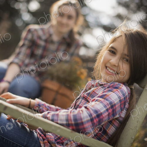 Two children sitting outdoors in a garden on an organic farm. Two children sitting outdoors in a garden on an organic farm.