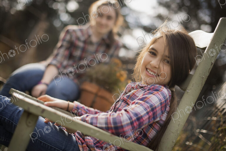Two children sitting outdoors in a garden on an organic farm.