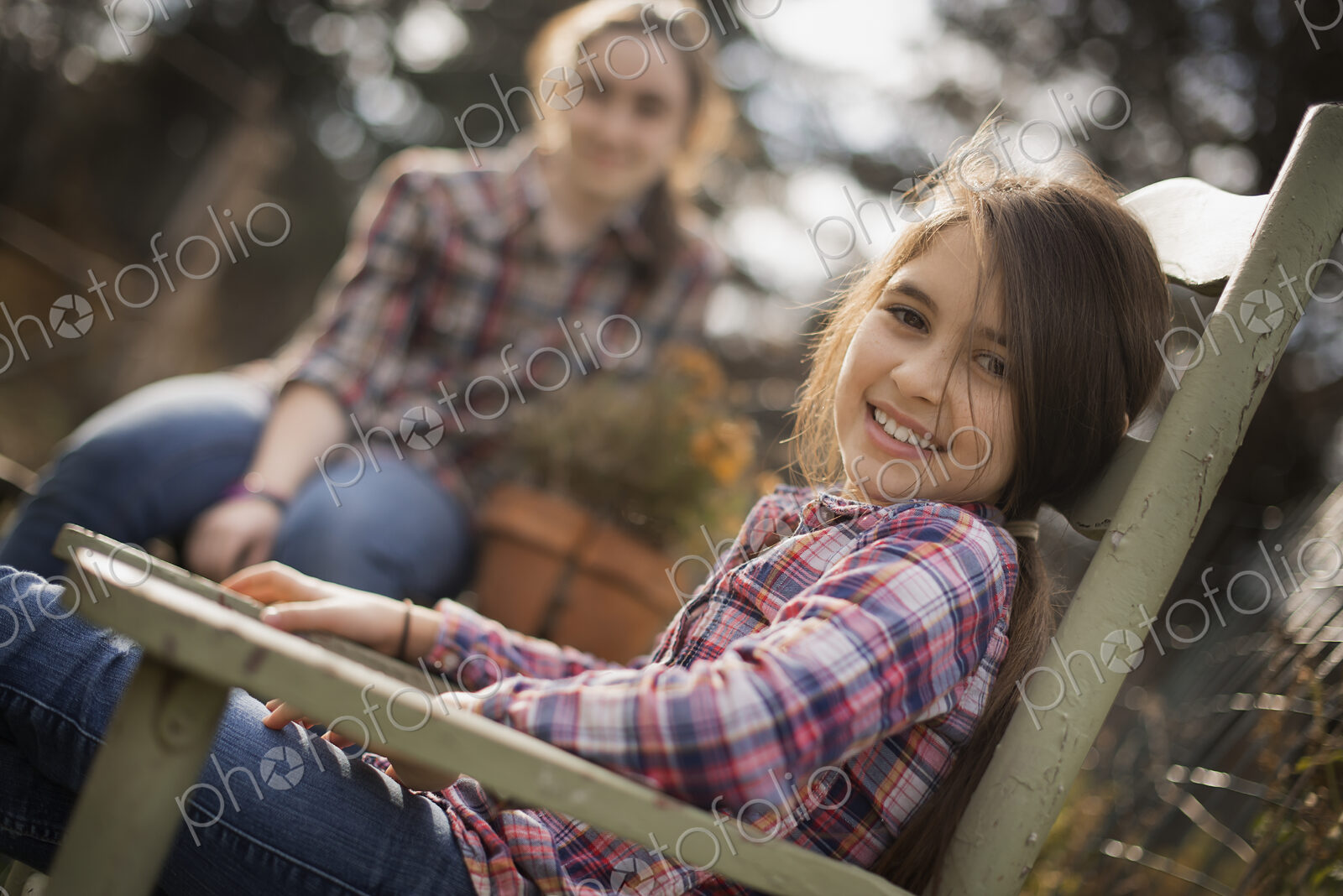 Two children sitting outdoors in a garden on an organic farm.