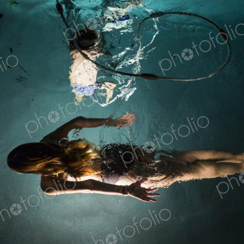 Two children swimming in pool at night Two children swimming in pool at night