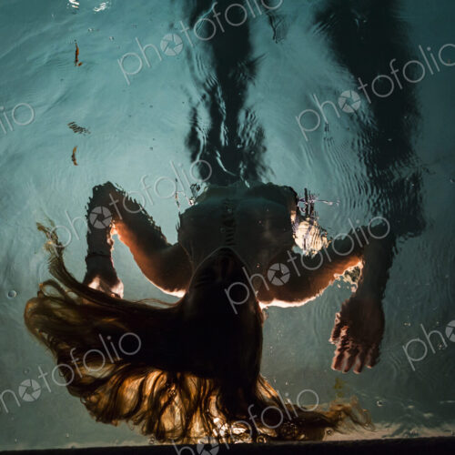 Two children swimming in pool at night Two children swimming in pool at night