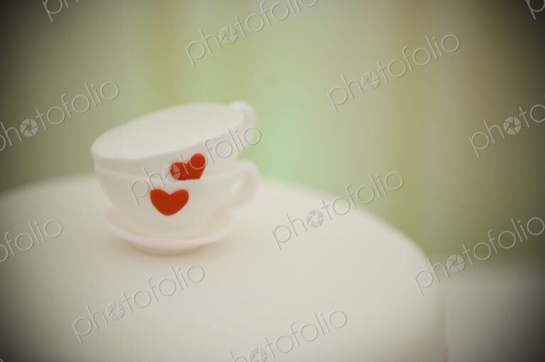 Two china cups stacked one on the other, and decorated with a red heart.