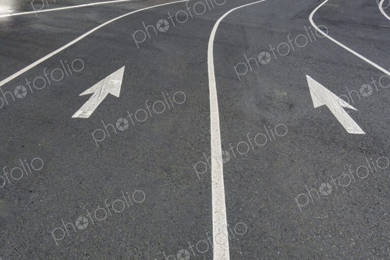 Two directional Arrow symbols on the road surface, on a city road in Seattle.