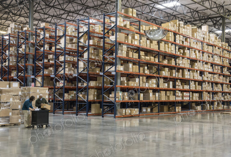 Two employees checking inventory in temporary storage in a distribution warehouse.