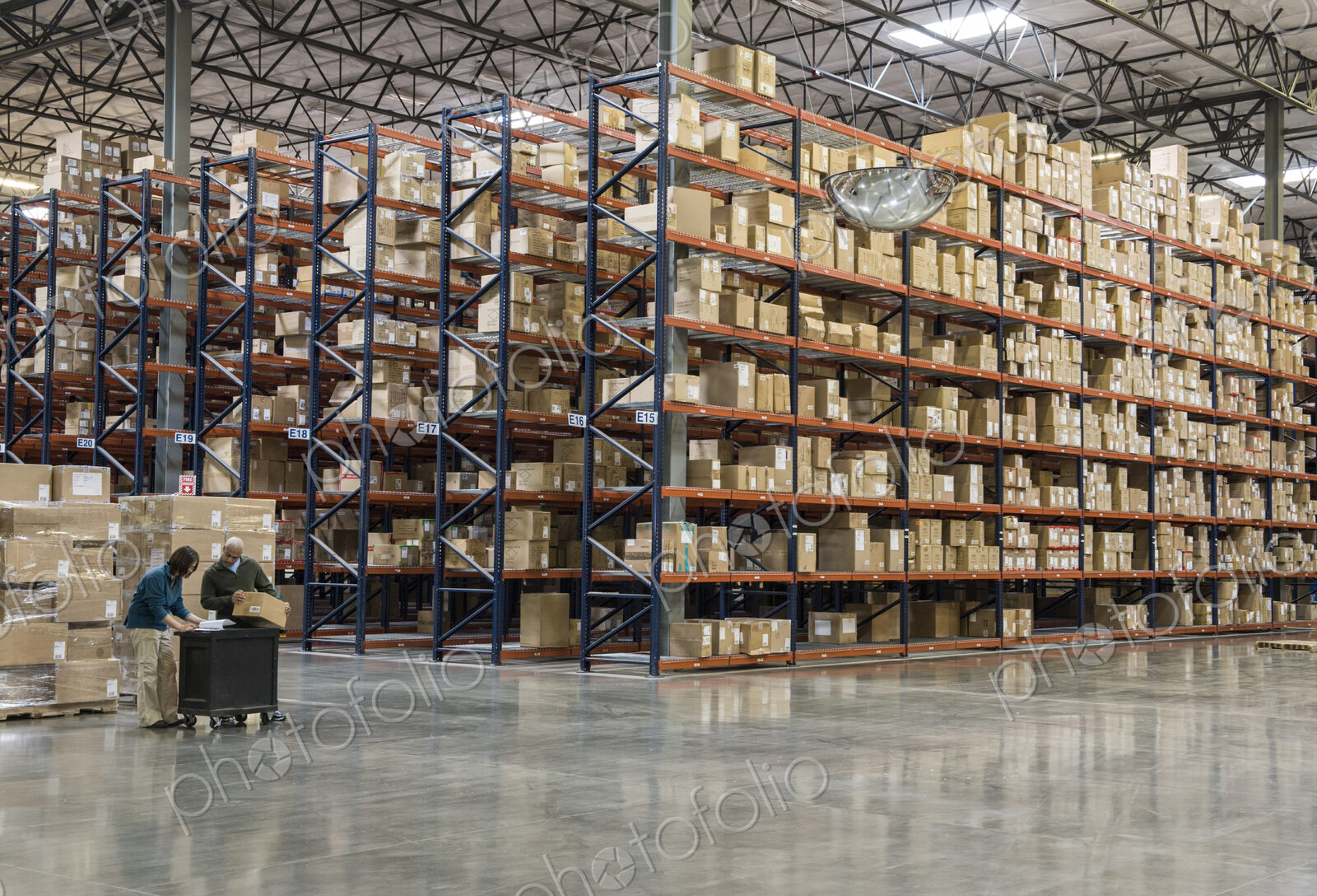 Two employees checking inventory in temporary storage in a distribution warehouse.