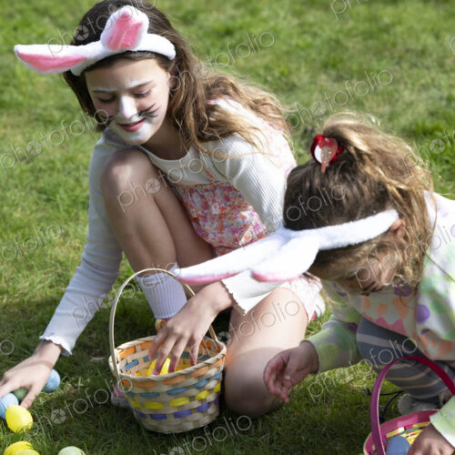 Two girls collecting Easter eggs in garden. Two girls collecting Easter eggs in garden.