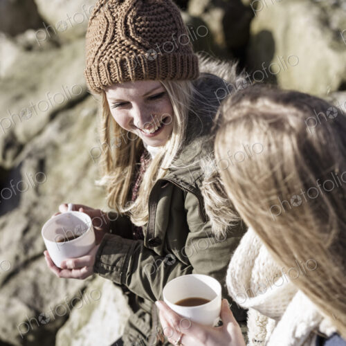 Two girls having a winter picnic on the beach.