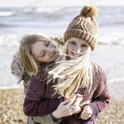 Two girls on the beach in winter.