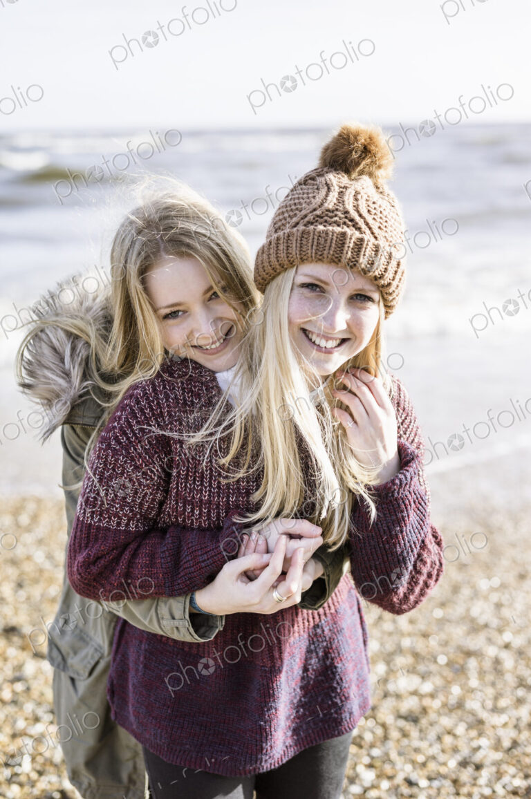 Two girls on the beach in winter.