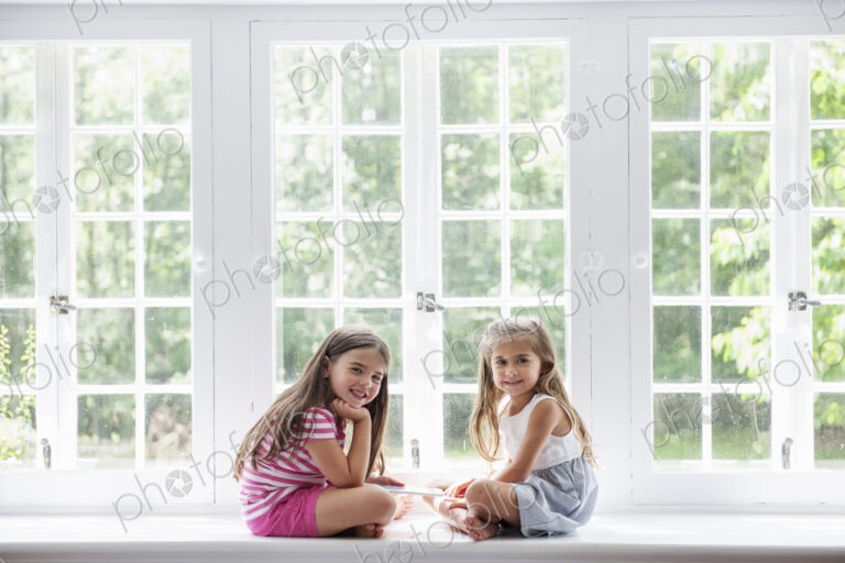 Two girls playing, sharing a digital tablet.