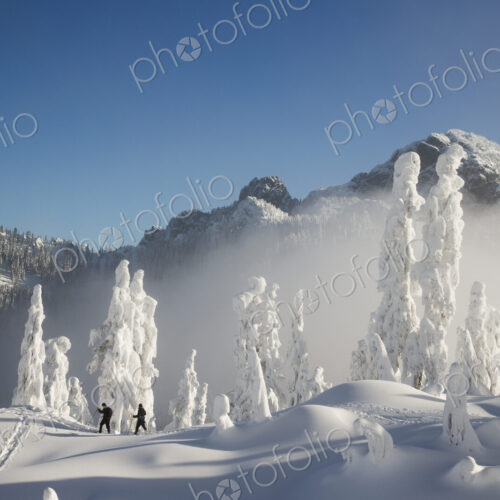 Two hikers enjoy a blue bird day in the middle of winter in the snow covered Cascade… Two hikers enjoy a blue bird day in the middle of winter in the snow covered Cascade…