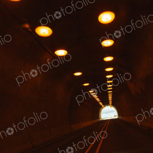 Two lane highway through a tunnel, view of the lights leading to the daylight and the… Two lane highway through a tunnel, view of the lights leading to the daylight and the…