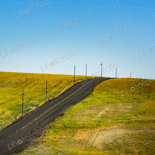 Two lane rural road in the Palouse near Ritzville on a hillside in meadows. Two lane rural road in the Palouse near Ritzville on a hillside in meadows.