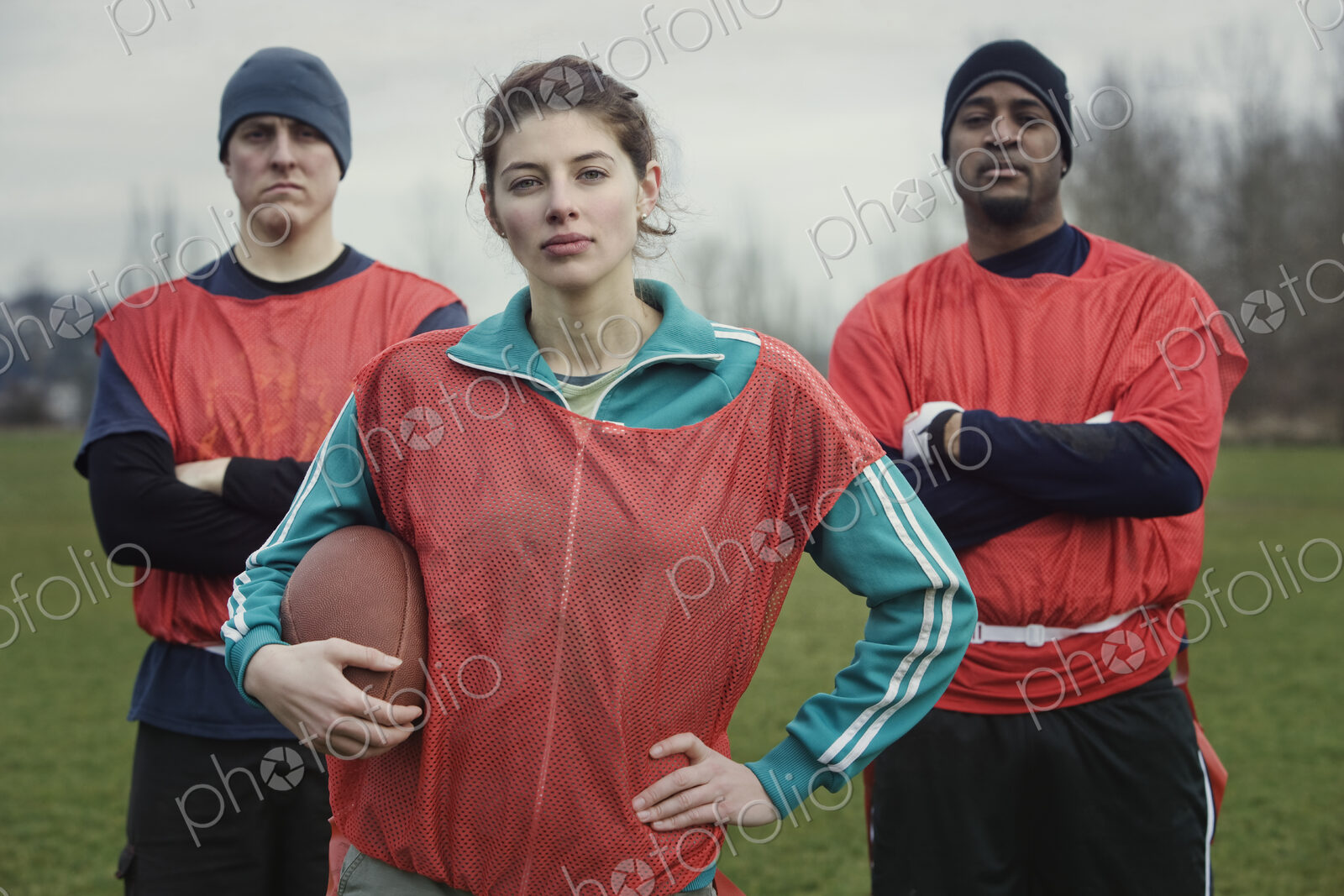 Two men and a woman, members of a team of American flag football players.
