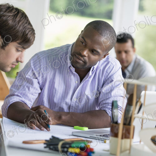 Two men seated, one drawing on paper Two men seated, one drawing on paper
