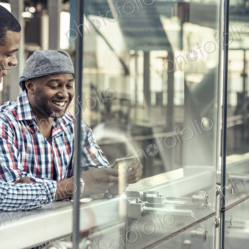 Two men side by side looking at a digital tablet