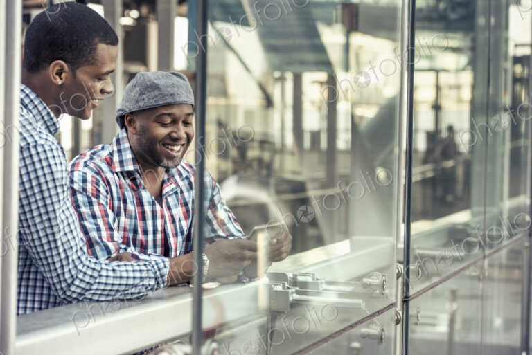 Two men side by side looking at a digital tablet