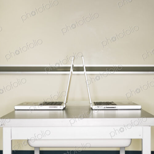 Two open laptops on a table. Two open laptops on a table.