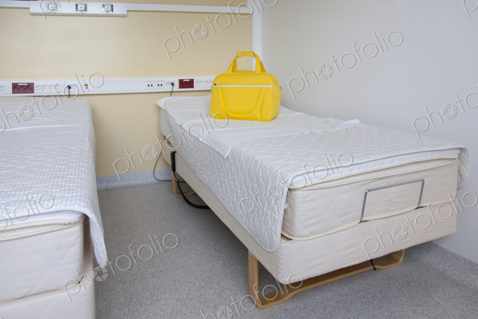 Two patient beds in a maternity unit, a bright yellow bag.