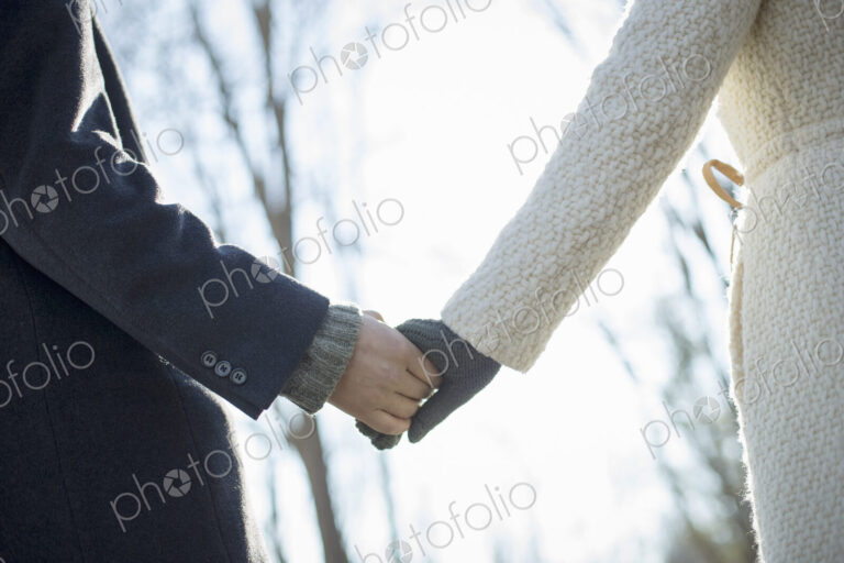 Two people, a couple, a man and woman in the woods on a winter day. Holding hands.