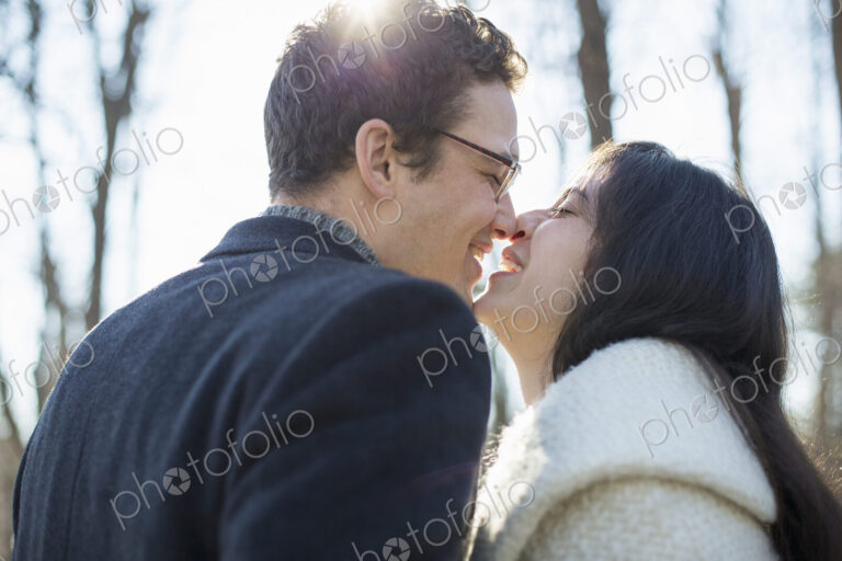 Two people, a couple, a man and woman in the woods on a winter day. Kissing.