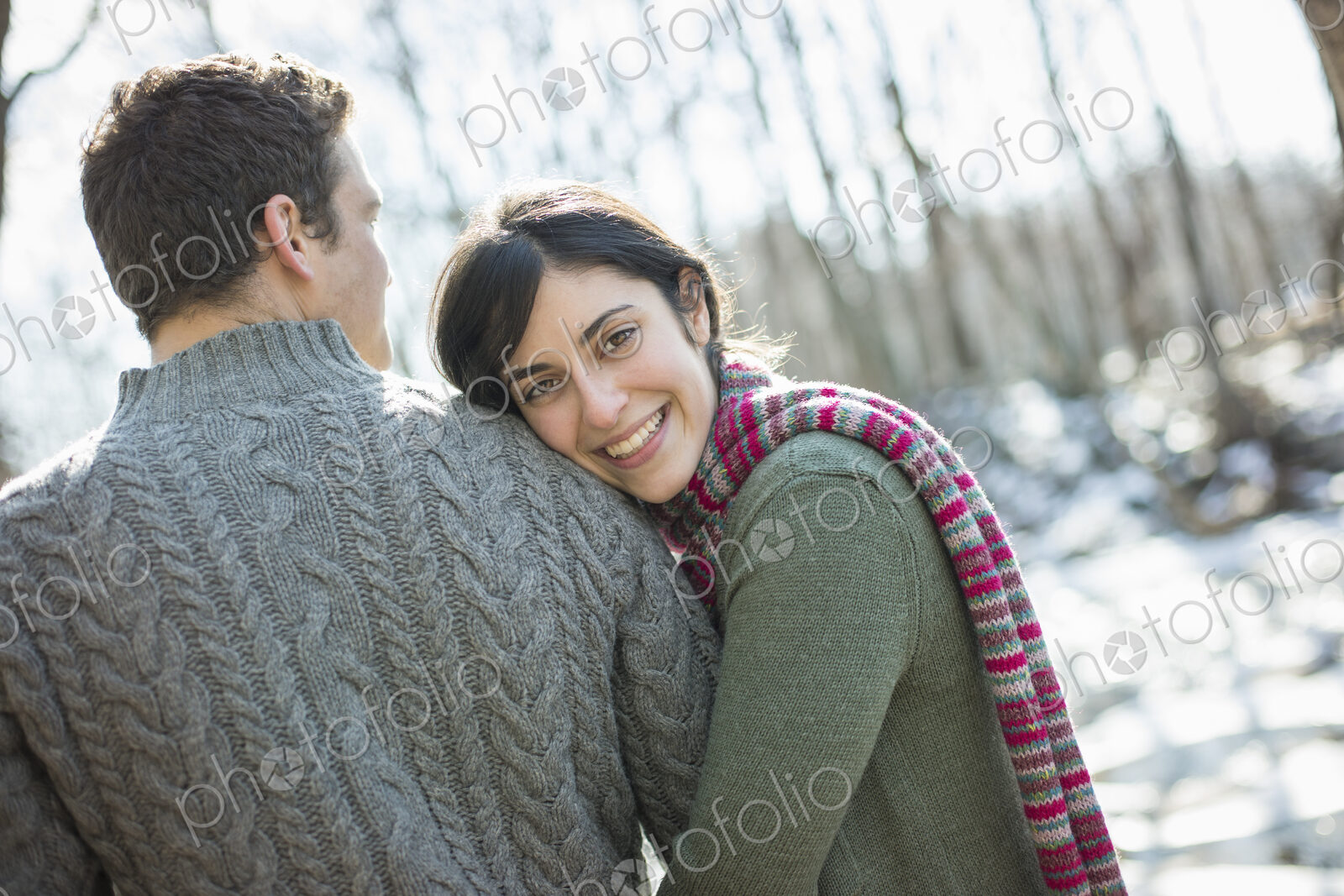 Two people, a couple outdoors on a winter day. Hugging each other.