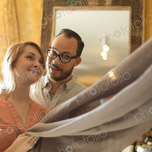 Two people, a couple running an antique store. Small business. Holding a piece of… Two people, a couple running an antique store. Small business. Holding a piece of…