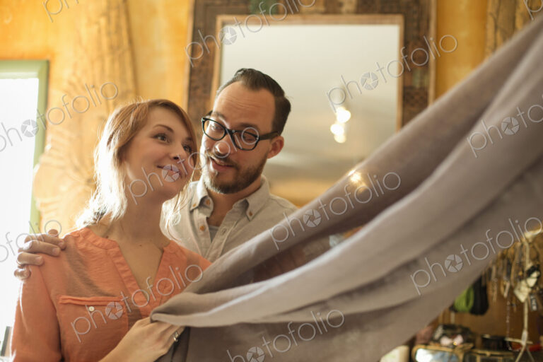 Two people, a couple running an antique store. Small business. Holding a piece of…