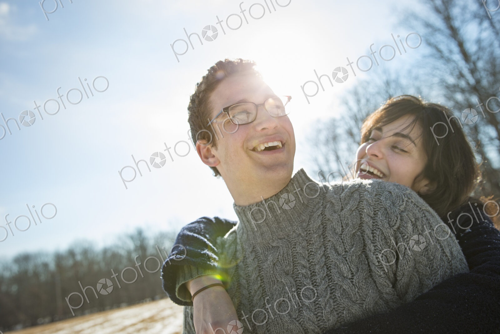 Two people, a man and a woman hugging each other and laughing. A walk on a winter day.