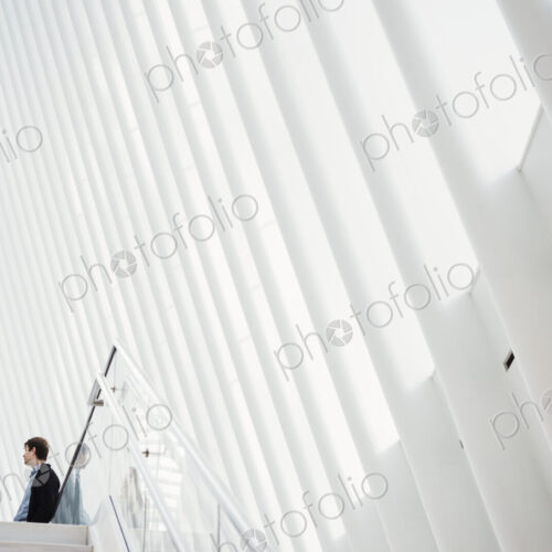 Two people at the top of steps in a tall airy central atrium of a public building. Two people at the top of steps in a tall airy central atrium of a public building.