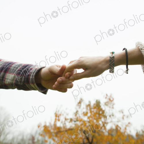 Two people holding hands, a couple outdoors. Two people holding hands, a couple outdoors.