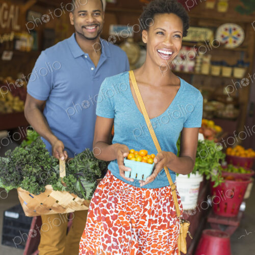 Two people in a farm shop, choosing organic vegetables. Two people in a farm shop, choosing organic vegetables.