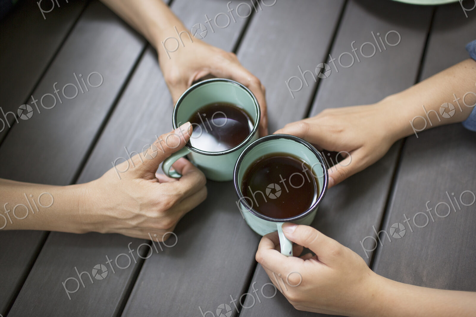 Two people seated at a table, drinking coffee, viewed from above.