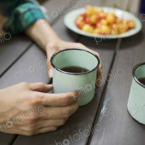 Two people seated at a table, drinking coffee, viewed from above. Two people seated at a table, drinking coffee, viewed from above.