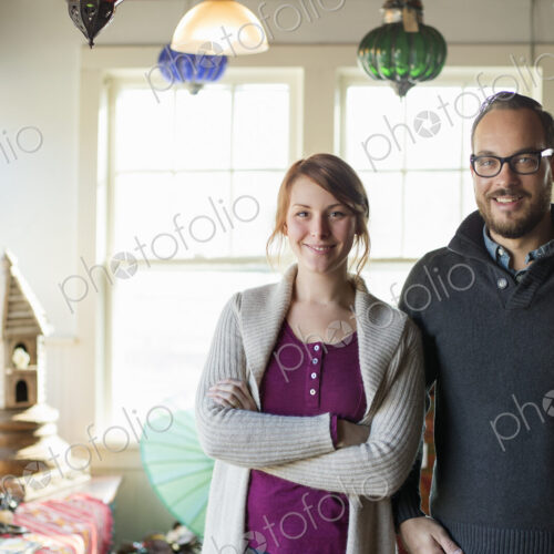 Two people standing in a store full of antique objects, a couple running a business. Two people standing in a store full of antique objects, a couple running a business.