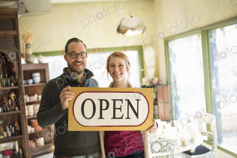 Two people standing in a store full of antique objects, a couple running a business.…