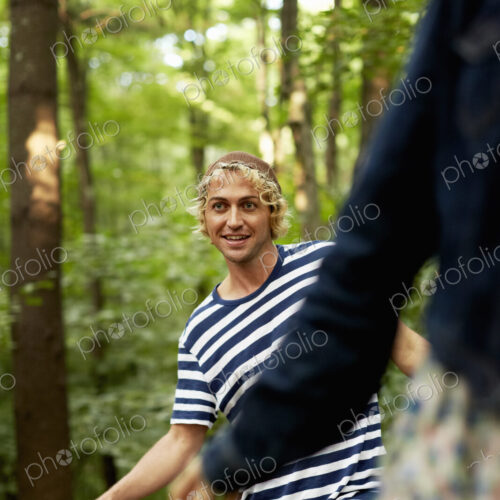 Two people walking along a fallen tree trunk in the woods. Two people walking along a fallen tree trunk in the woods.