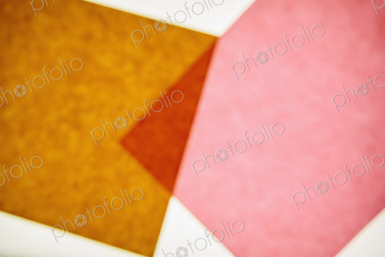 Two pieces of recycled construction paper, brown and pink with a small overlapping…