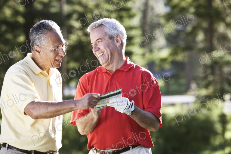 Two senior friends laughing about a golf score on a local golf course.