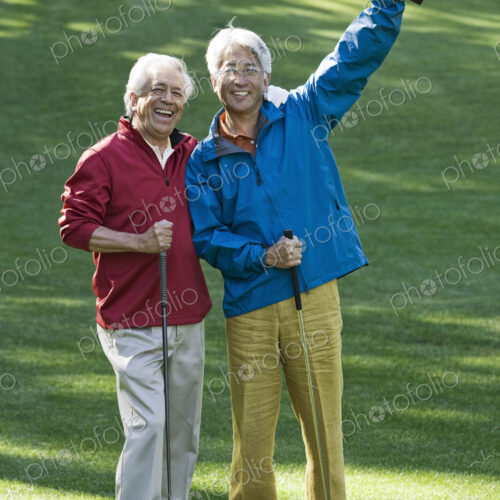 Two senior male golfing buddies with a trophy they just won playing golf.