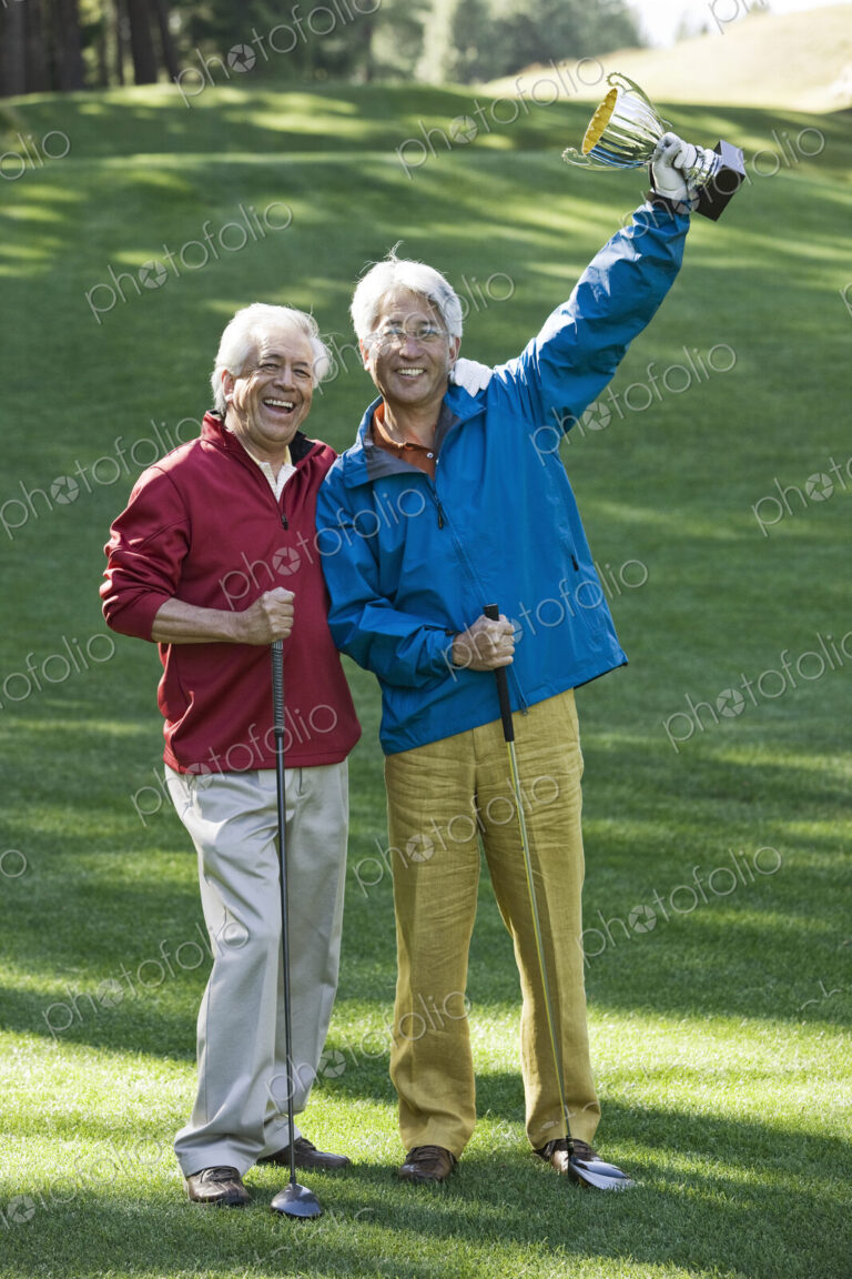 Two senior male golfing buddies with a trophy they just won playing golf.