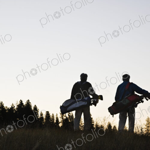 Two seniors walking down the fairway toward the next golf green.
