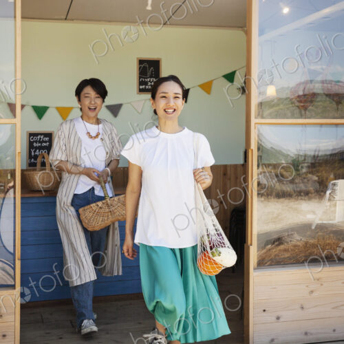 Two smiling Japanese women leaving farm shop. Two smiling Japanese women leaving farm shop.